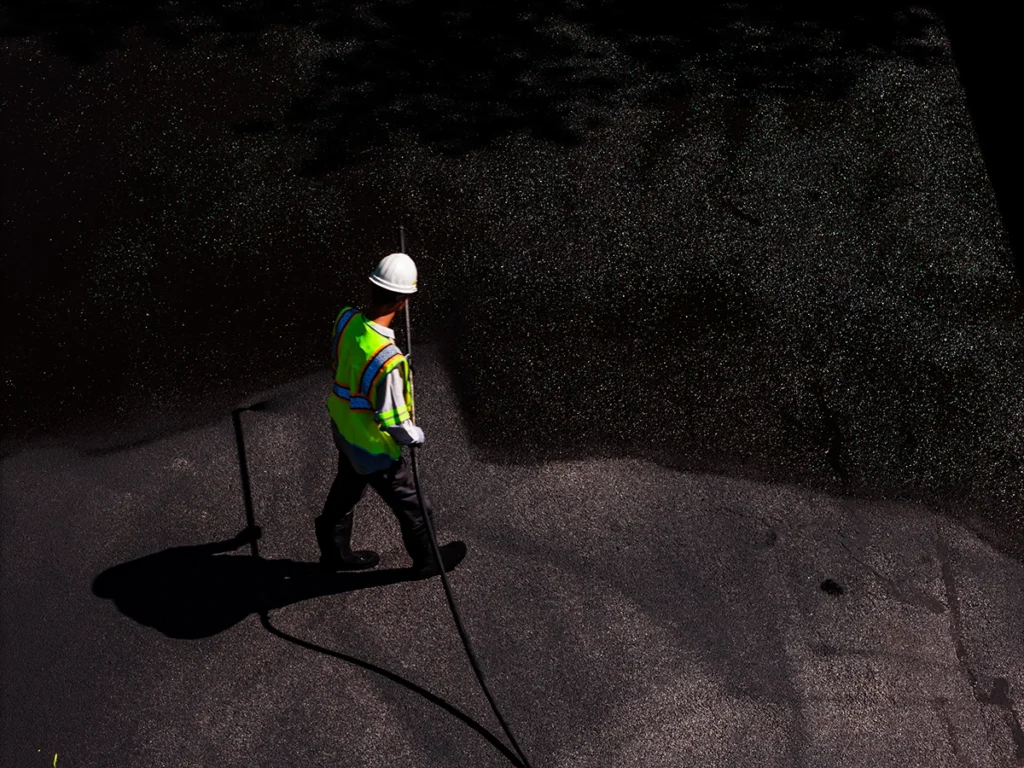 Asphalt Lifespan: How Weather and Traffic Load Affect It - Kansas Asphalt asphalt sealcoating being performed in a commercial parking lot